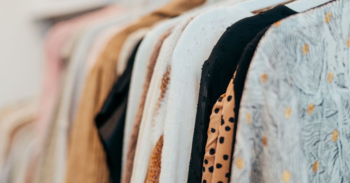 A close-up view of fashionable clothes hanging on racks in a boutique setting, showcasing various patterns and textures.